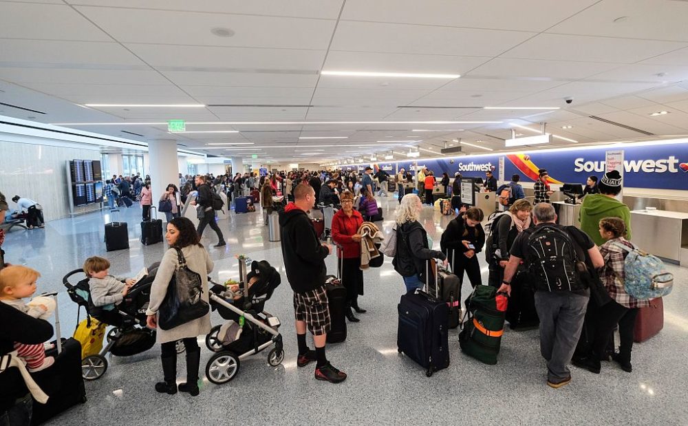 Holiday travelers crowd check in before departure. (Ringo Chiu/AFP via Getty Images)
