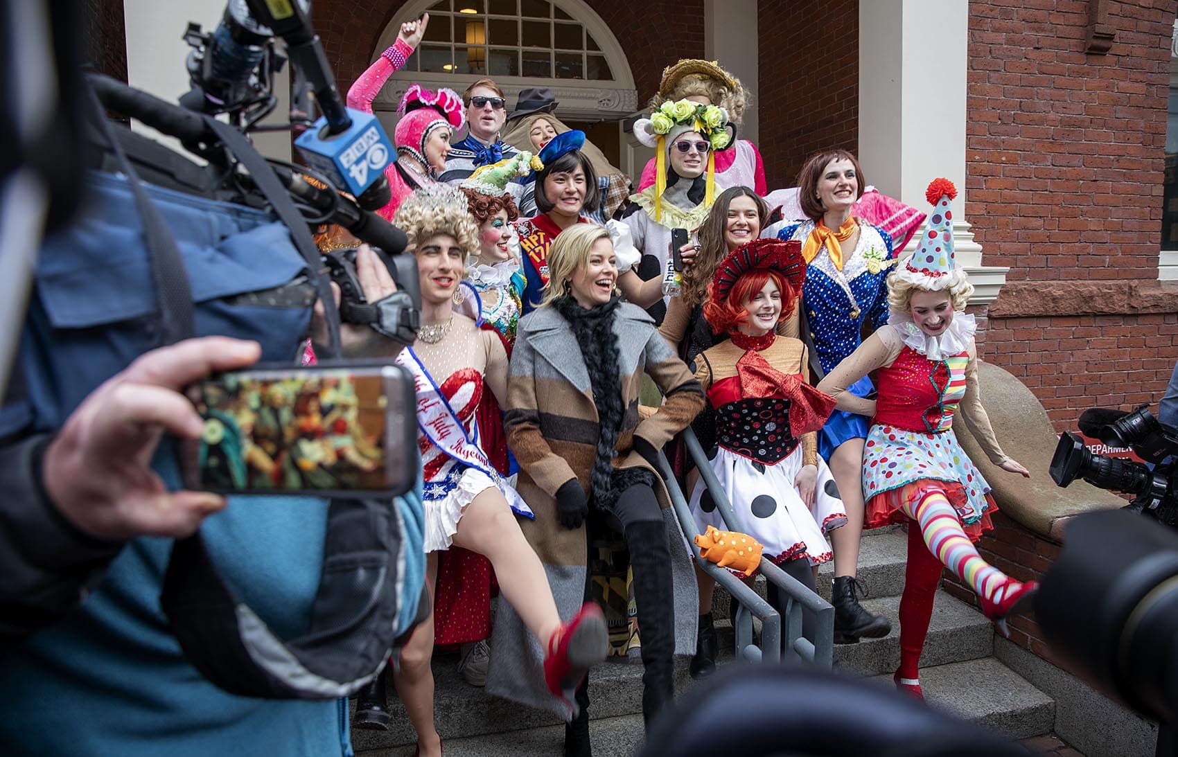 Elizabeth Banks, Hasty Pudding Theatricals’ 2020 Woman of the Year, lines up with Hasty Pudding actors for a photo on the steps of Farkas Hall. (Robin Lubbock/WBUR)