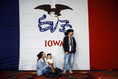 Natalie Serrano, left, and Isaac Garcia watch caucus returns come in with their son Leonel, 2, at a Sen. Bernie Sanders, caucus night campaign rally in Des Moines, Iowa Monday. (Matt Rourke/AP)