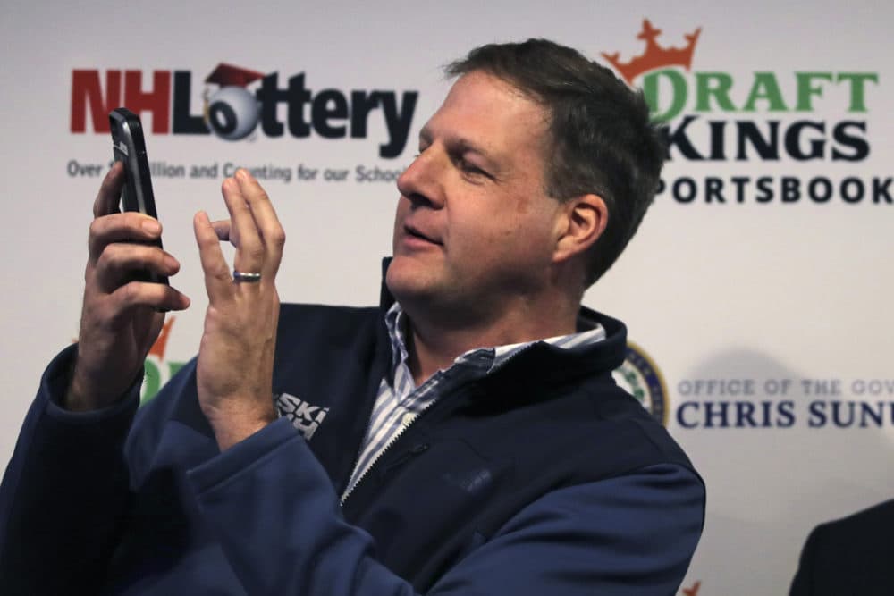 New Hampshire Gov. Chris Sununu places the first legal sports wagering bet on his mobile phone for the New England Patriots to win the Super Bowl at a sports bar in Manchester, N.H., Monday, Dec. 30, 2019. New Hampshire, who partnered with DraftKings, is the second New England state to approve sports wagering. (Charles Krupa/AP)