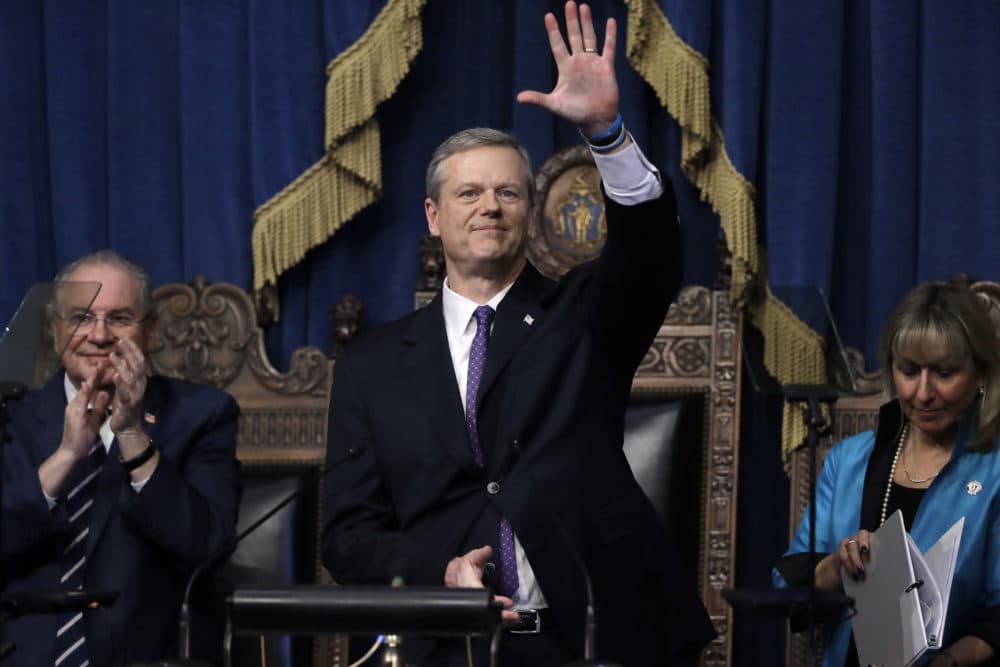Massachusetts Gov. Charlie Baker, center, waves at the conclusion of his state of the state address in the House Chamber as Speaker of the House Robert DeLeo, behind left, and Senate President Karen Spilka, right, look on, Tuesday, at the State House. (Steven Senne/AP)