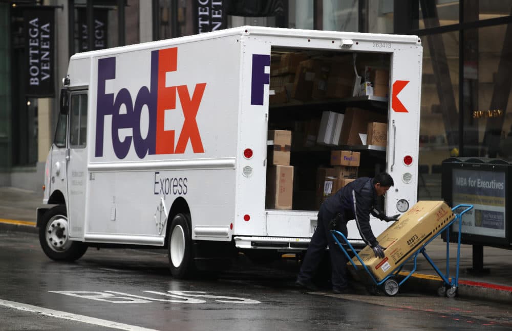 A FedEx worker stacks packages on a cart in San Francisco, California. (Justin Sullivan/Getty Images)