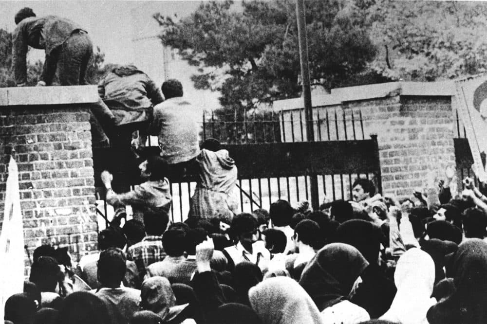 Iranian students climb over the wall of the US embassy in Tehran 04 November 1979. Twenty years later, 04 November 1999, the former embassy building now turns out officers of the Islamic Republic's Revolutionary Guards. / AFP / IRNA / STR        (Photo credit should read STR/AFP via Getty Images)