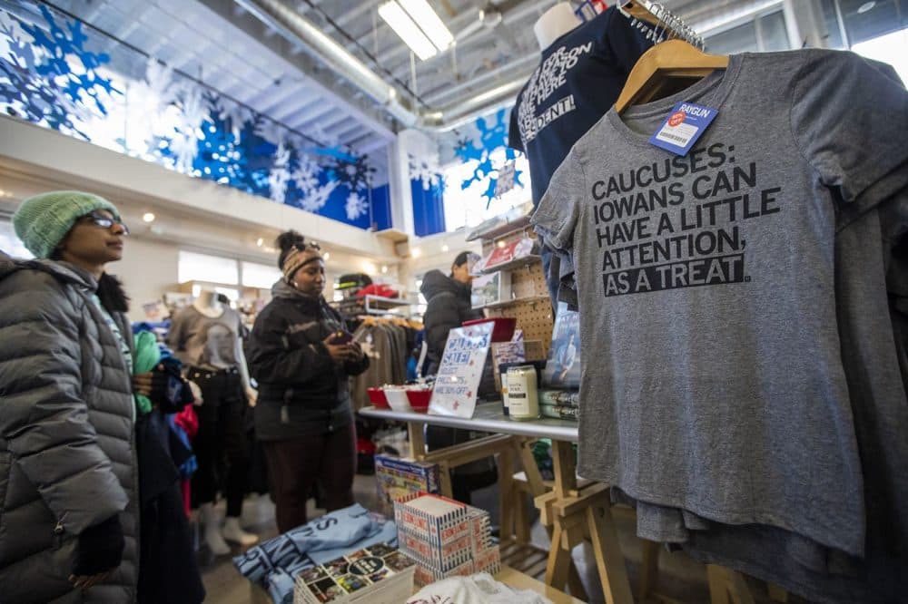Shoppers at RAYGUN in Des Moines peruse the selection of printed t-shirts and other items with various quips about the Iowa caucus. (Jesse Costa/WBUR)