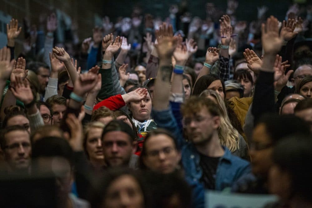 Caucus participants at Central Campus High School raise their hands to be counted, Feb, 3, 2020. (Jesse Costa/WBUR)