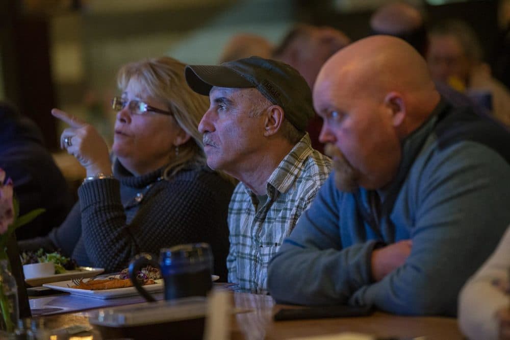 (L-R) Terry Dwyer, her husband Bob Trott, and Dennis Roberts sit at the bar at Revolution TapRoom and Grill in Rochester, NH. (Jesse Costa/WBUR)