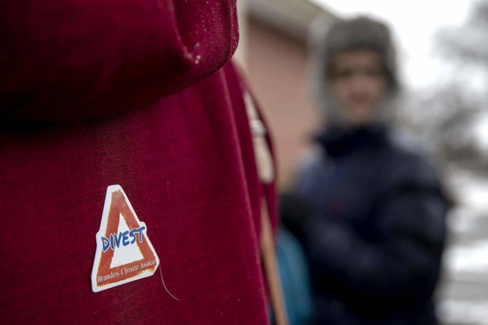 A protester wore a &quot;Divest&quot; sticker at a Brandeis Climate Justice demonstration at the university in February. (Robin Lubbock/WBUR)