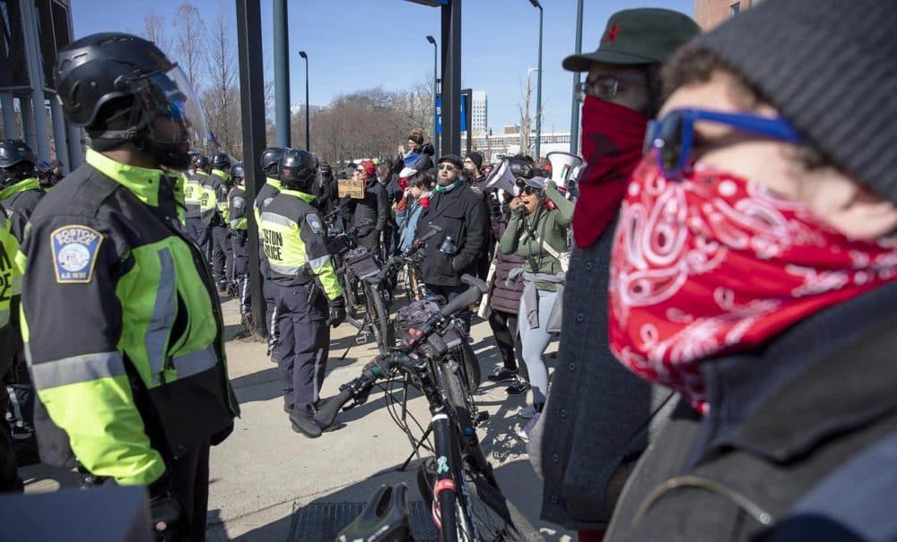 A line of bicycle police keeps counter-protesters separated from a group of Super Happy Fun America demonstrators in front of Boston Police Headquarters. (Robin Lubbock/WBUR)