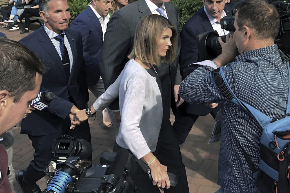 On Aug. 27, 2019, actress Lori Loughlin departs hand in hand with her husband, clothing designer Mossimo Giannulli, left, in Boston, after a hearing in federal court in a nationwide college admissions bribery scandal. (Philip Marcelo/AP File Photo)