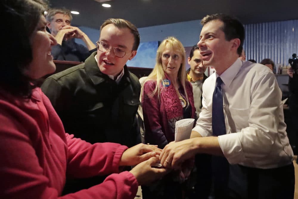 Democratic presidential candidate former South Bend Mayor Pete Buttigieg, right, and his husband, Chasten Buttigieg, left, greet people at a campaign event Tuesday in Hampton, N.H. (Elise Amendola/AP)