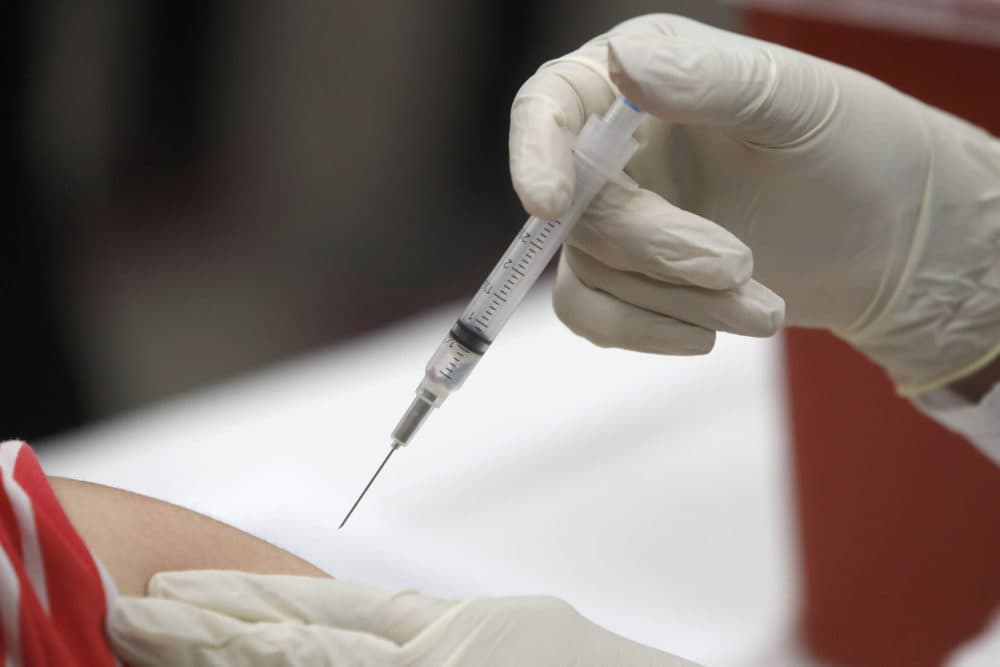 A syringe with influenza vaccine inside heads for its mark during a flu vaccination at Eastfield College in Mesquite, Texas. (L.M. Otero/AP)
