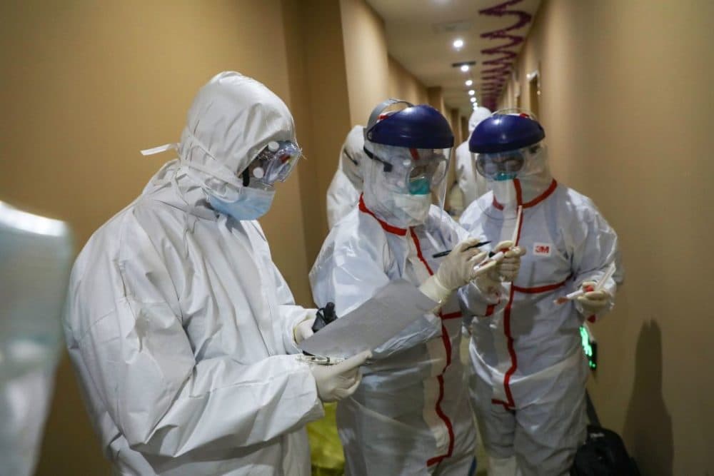 A medical staff member marks a test tube containing samples taken from a person to be tested for the new coronavirus at a quarantine zone in Wuhan.