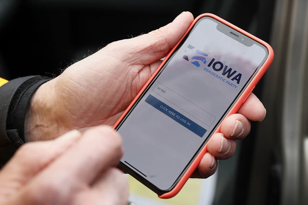 Precinct captain Carl Voss holds his iPhone that shows the Iowa Democratic Party's caucus reporting app Tuesday, Feb. 4, 2020, in Des Moines, Iowa. (Charlie Neibergall/AP Photo)
