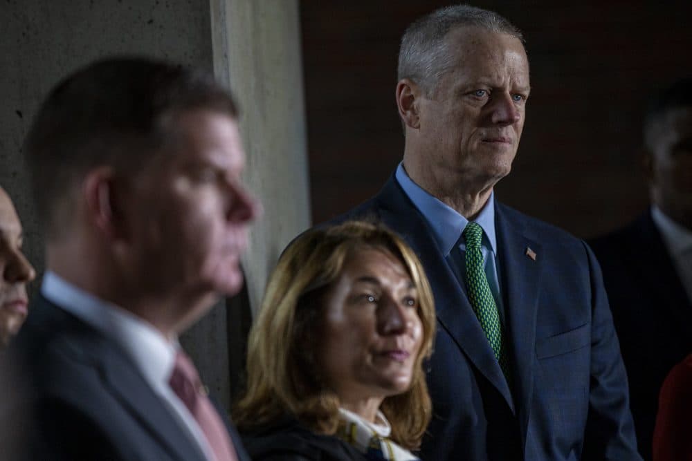 Gov. Charlie Baker (right), looks on at a press conference on City Hall Plaza, along with Boston Mayor Marty Walsh and Lt. Gov. Karyn Polito. (Jesse Costa/WBUR)
