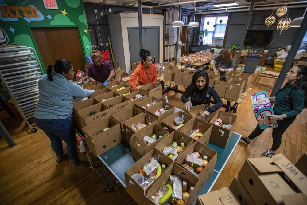 Workers at UTEC assemble meal boxes for their young people at home since the program is shut down. (Jesse Costa/WBUR)