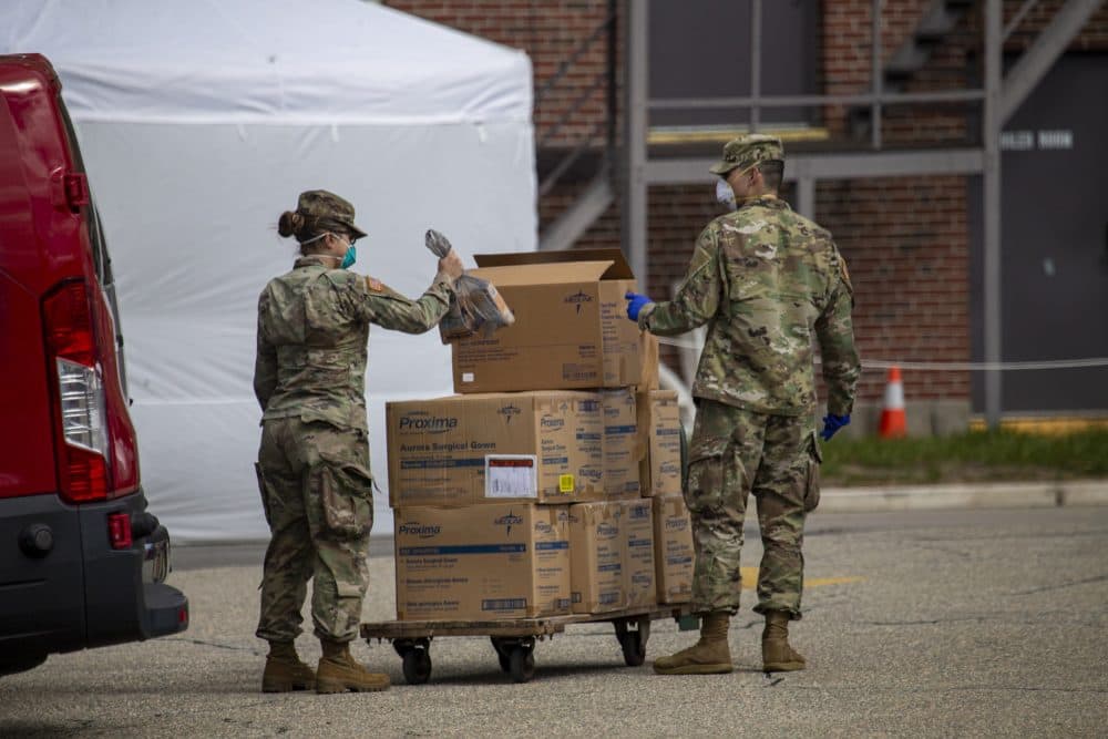 Members of the National Guard load boxes of protective gear onto a cart at the Soldiers’ Home — a state-run long-term residence and health facility in Holyoke where 11 veterans have died following a coronavirus outbreak — on March 31. (Jesse Costa/WBUR)