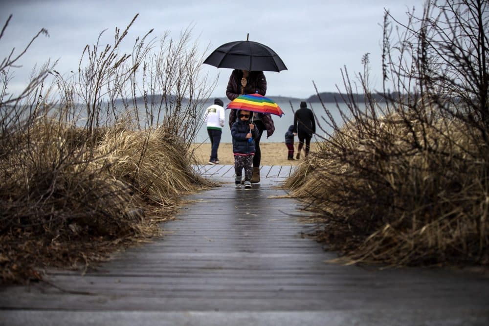 Two-year-old Jonah Klein and his mother Stephanie return from a quick morning walk in the cold rain along Carson Beach in South Boston. (Jesse Costa/WBUR)