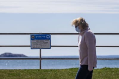 A signs hang at Kings Beach in Swampscott listing the CDC recommendations for social gathering during the COVID-19 pandemic. (Jesse Costa/WBUR)