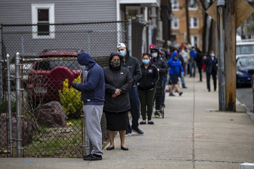 A line extends down Chestnut Street for food distribution being done by the Salvation Army in Chelsea. (Jesse Costa/WBUR)