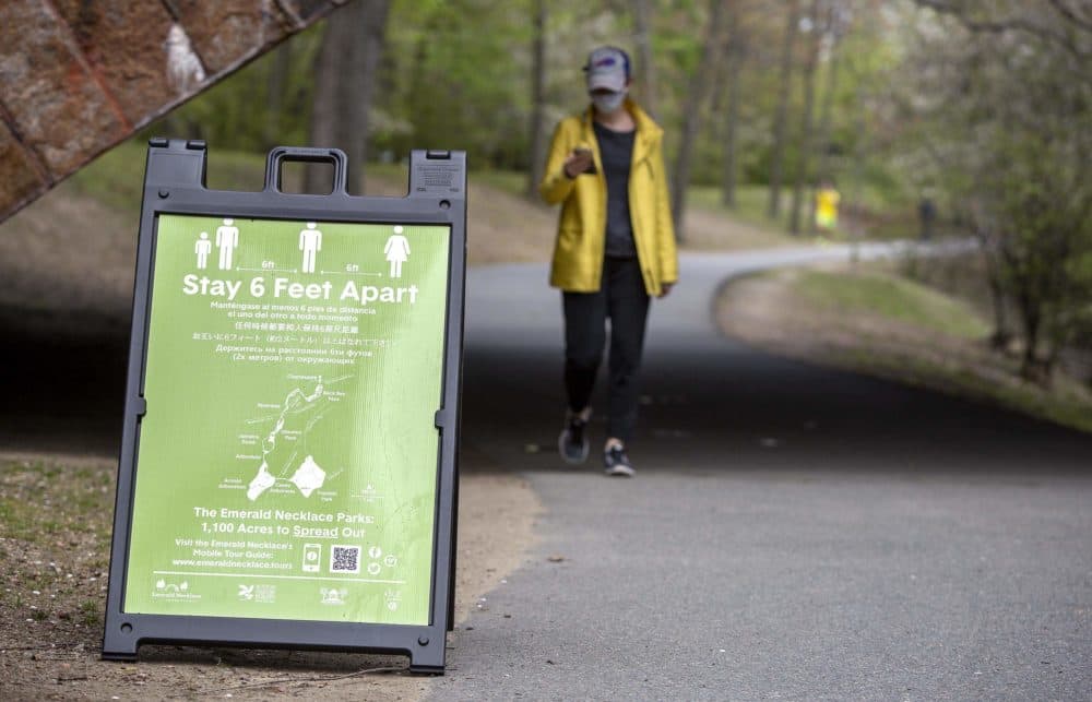 A sign urging social distancing in Brookline on the Emerald Necklace pathway. (Robin Lubbock/WBUR)