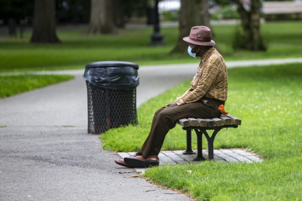 An elderly man rests on a bench in the Boston Public Garden. (Jesse Costa/WBUR)