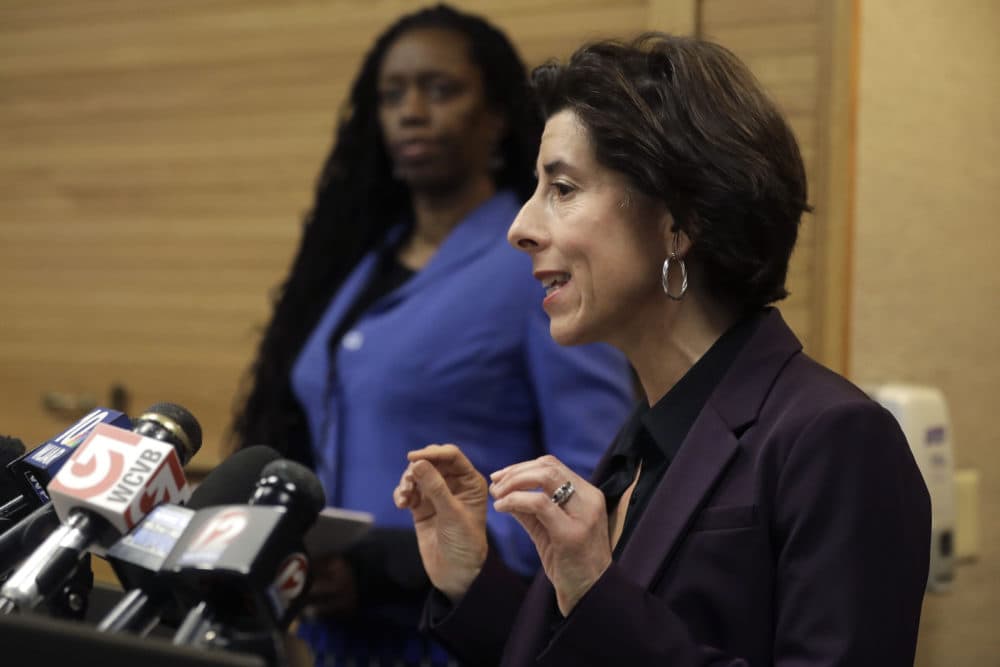Rhode Island Gov. Gina Raimondo (right) and R.I. Director of Health Nicole Alexander-Scott (behind) face reporters during a news conference on COVID-19. (Steven Senne/AP)