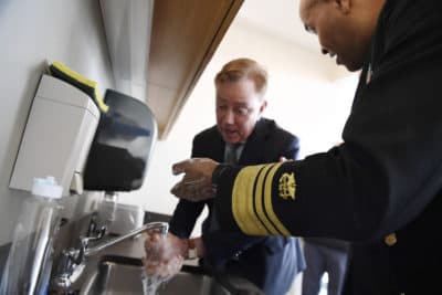 U.S. Surgeon General Vice Admiral Jerome M. Adams demonstrates how long to wash hands with Connecticut Gov. Ned Lamont. (AP Photo/Jessica Hill)