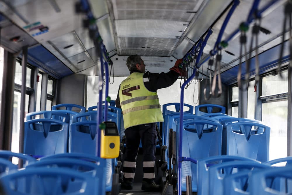 A worker sanitizes a public transport bus following the coronavirus emergency, in Rome, Friday, March 6, 2020. The Italian government has ordered all sporting events to take place without spectators and has urged the cancellation of all mass gatherings. (Cecilia Fabiano/LaPresse via AP)