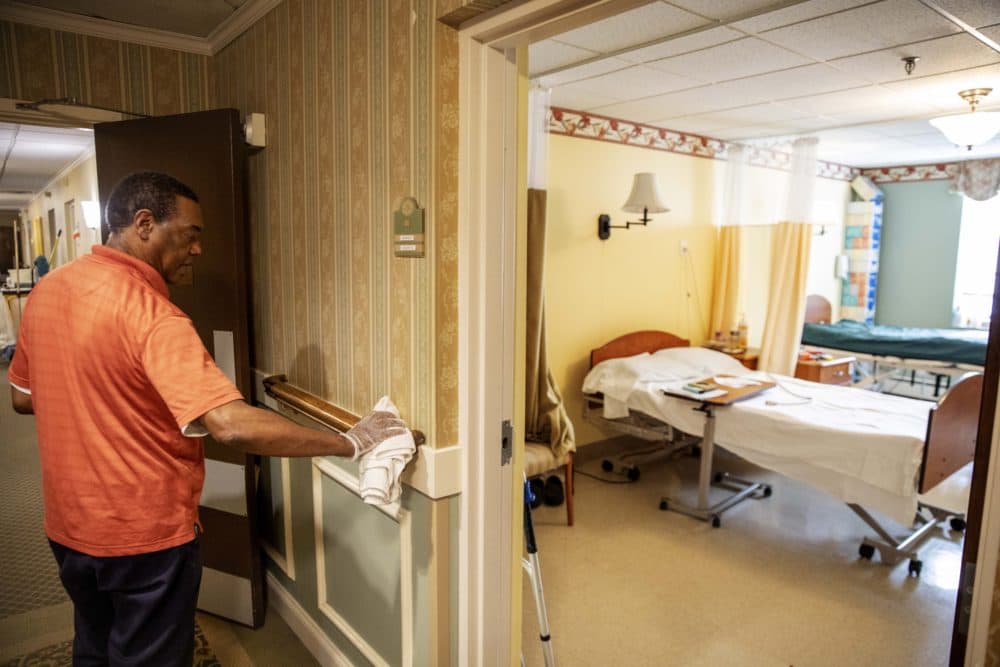 A worker at a nursing home sanitizes a handrail. (David Goldman/AP)