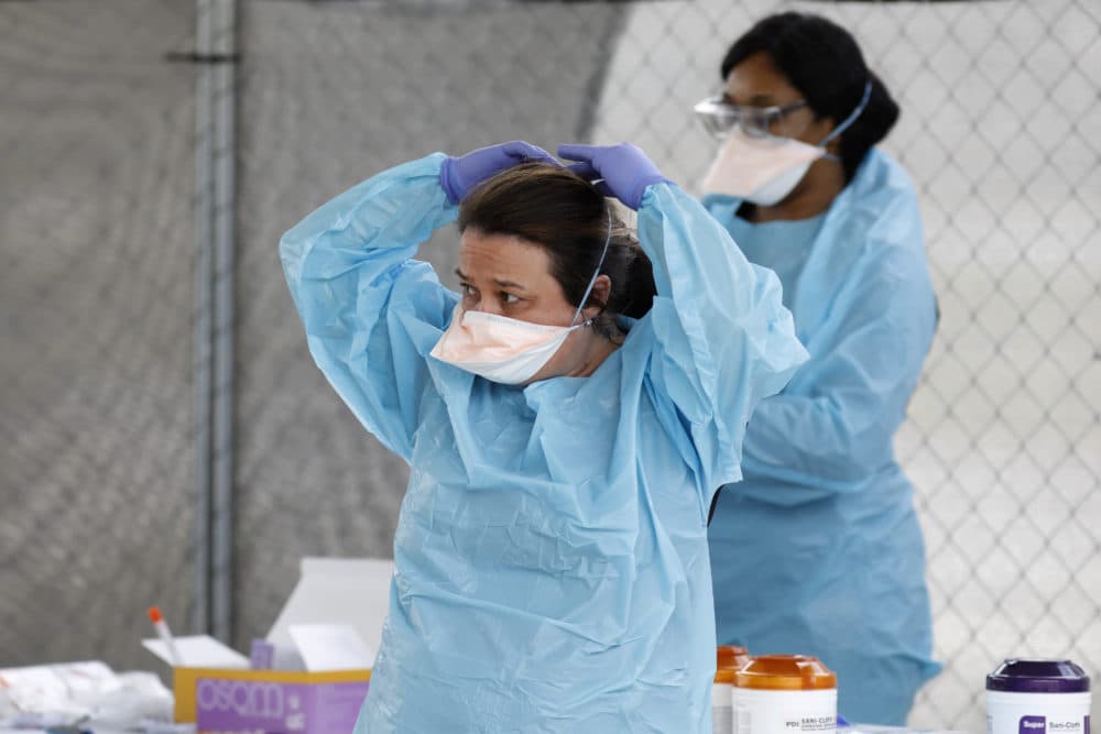 Raeanne Castillo with Roper St. Francis Healthcare puts on a protective mask at the hospital's North Charleston office Monday, March 16, 2020, in North Charleston, S.C. (Mic Smith/AP)