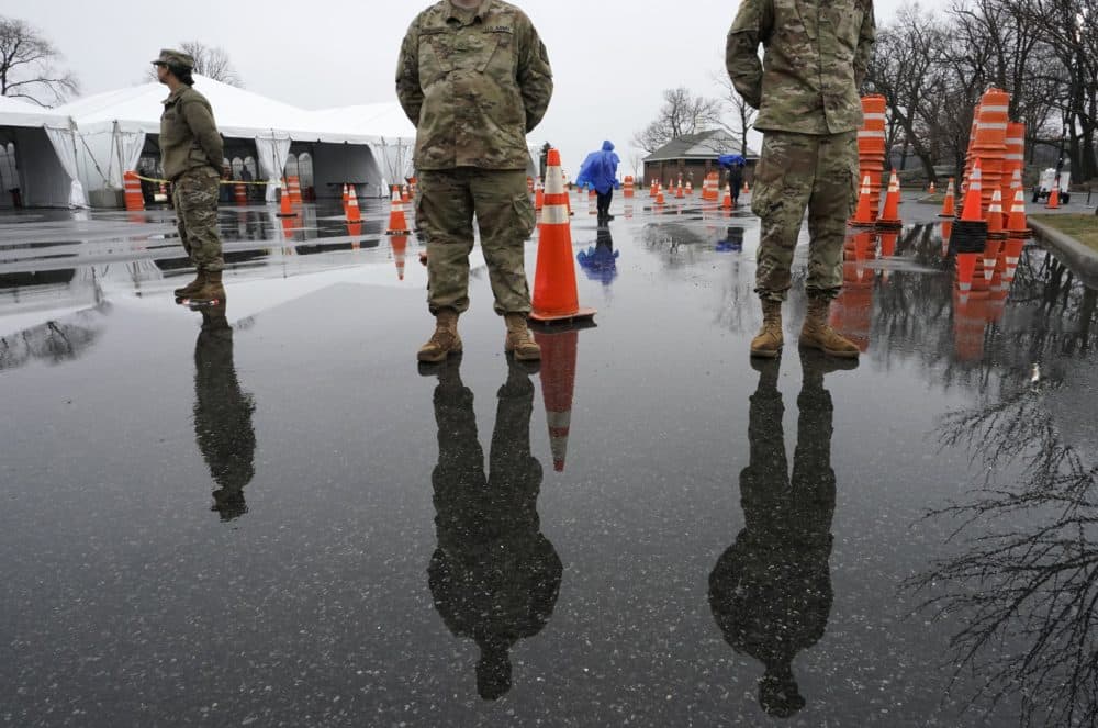 National Guard troops stand by as people wait to be tested for coronavirus at the state's first drive through mobile testing center at Glen Island Park in New Rochelle, New York on March 13. (Timothy A. Clary/AFP via Getty Images)