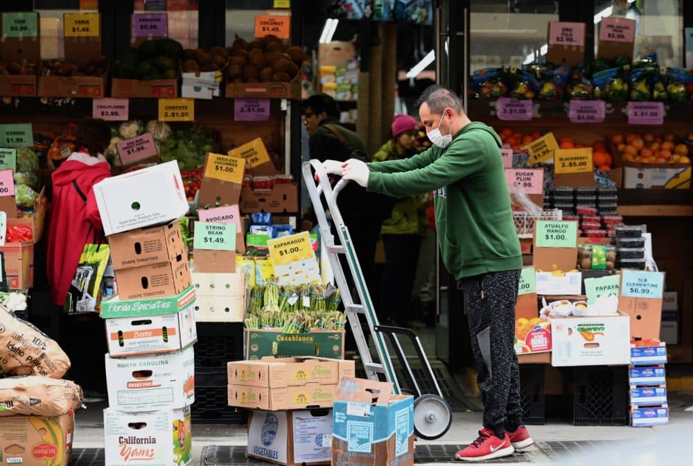 A worker stocks up on groceries at a local supermarket on March 20 in the Brooklyn, New York. (Angela Weiss/AFP/Getty Images)