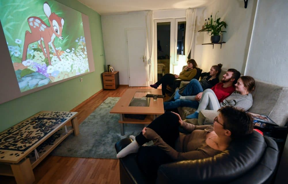 Members of a flat-sharing community watch the 'Bambi' film of Disney at their living room, in Dortmund, western Germany, on March 27, 2020, amidst the pandemic of the new coronavirus COVID-19. (INA FASSBENDER/AFP via Getty Images)