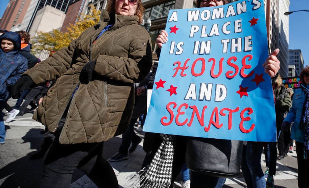 A woman holds a sign during a rally and march on October 13, 2018 in Chicago. (Kamil Krzaczynski/AFP/Getty Images)