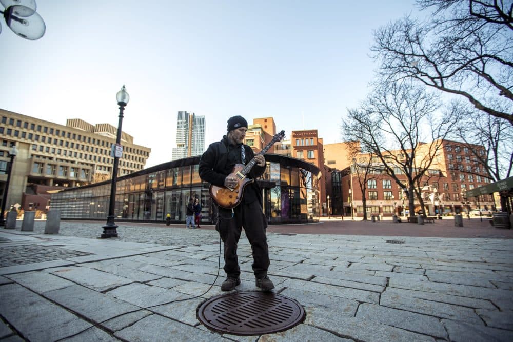 Street guitarist Matty X plays to an empty Faneuil Hall in late March. Faneuil Hall retailers have been pushing for a reprieve on April rent after last month's shuttering of non-essential businesses amid the coronavirus pandemic. (Jesse Costa/WBUR)