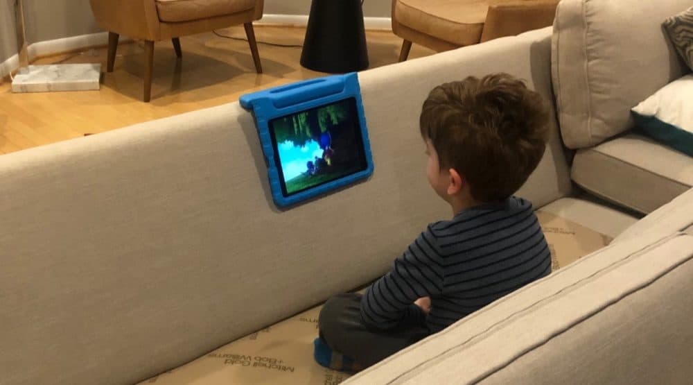 The author's son, Oliver, watches his tablet on the family's living room couch, which was in the process of becoming a fort. (Courtesy of Chloe I. Cooney)