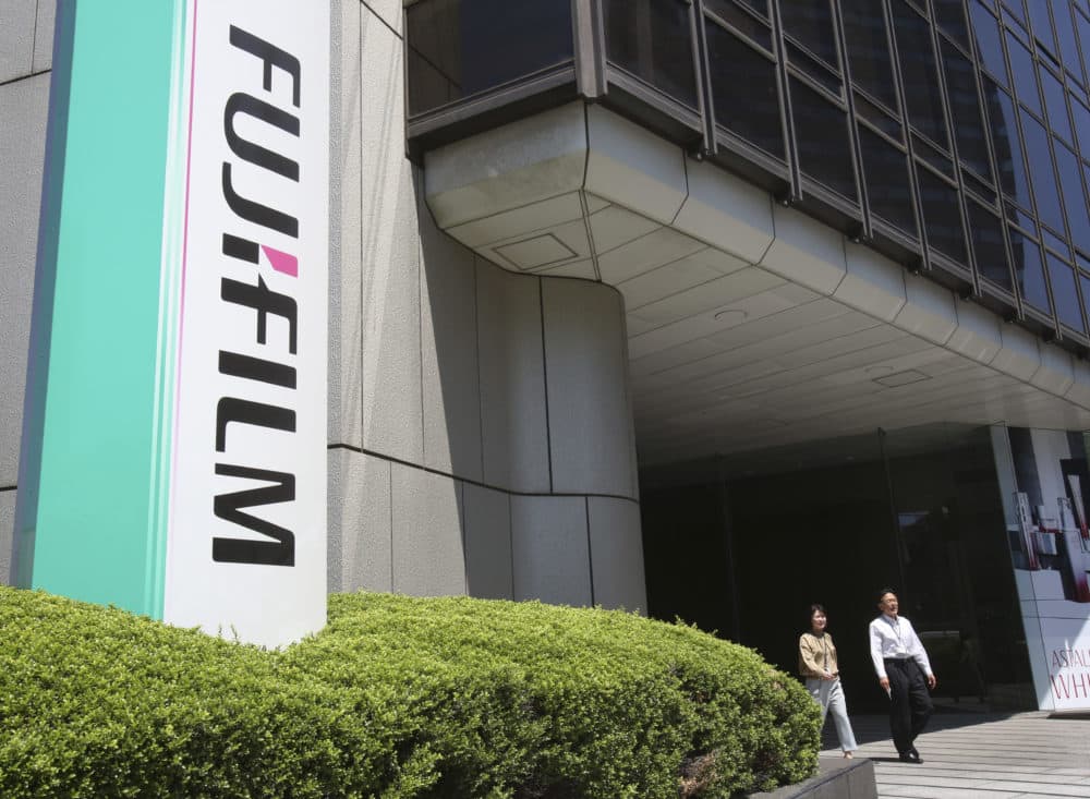 People walk out of Nishiazabu headquarters of Fujifilm Holdings Corporation in Tokyo. (Koji Sasahara/AP)