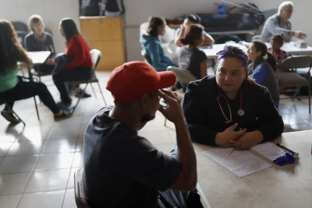 In this Dec. 14, 2019, photo, Dr. Psyche Calderon, right, works with a patient in a shelter for migrants in Tijuana, Mexico. (Gregory Bull/AP)