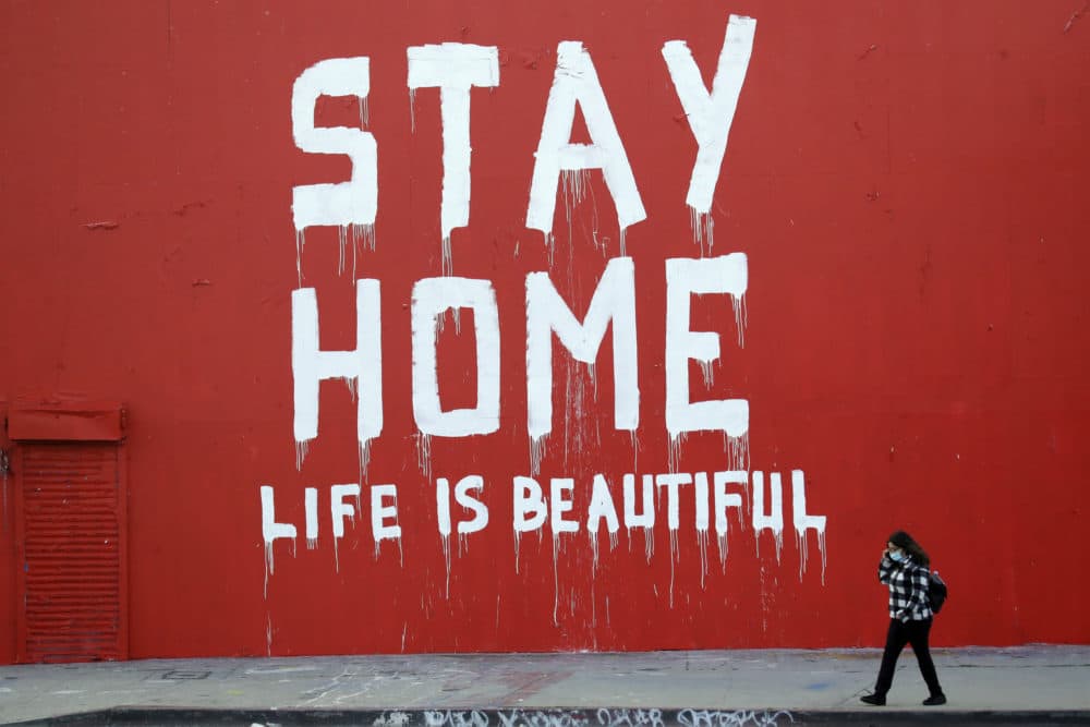 A pedestrian walks past a mural which reads &quot;Stay at Home, Life is Beautiful&quot; Thursday, April 2, 2020, in Los Angeles. (Marcio Jose Sanchez/AP Photo)