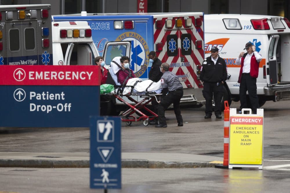 An ambulance crew transports a patient at the Massachusetts General Hospital emergency entrance in April (Michael Dwyer/AP)
