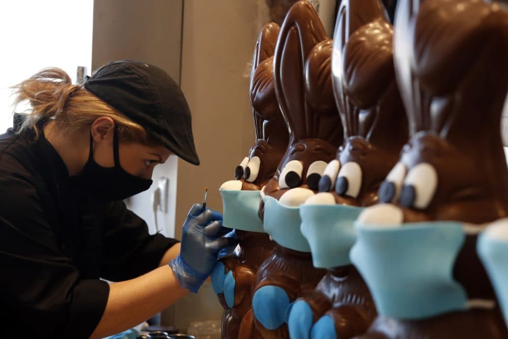 An employee of cake shop prepares chocolate Easter bunnies with masks in Lykovrisi, northern Athens, on Wednesday, April 8, 2020. (Thanassis Stavrakis/AP)
