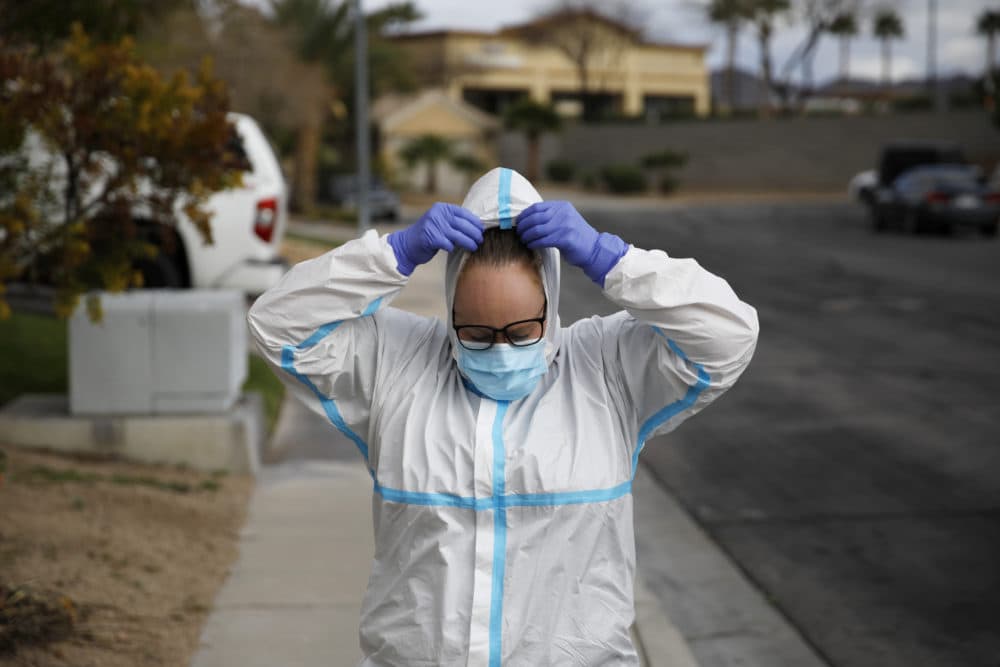 Paramedic Chelsea Monge of Ready Responders removes personal protective equipment after making a house call for a possible coronavirus patient Friday, April 10, 2020, in Henderson, Nev. (John Locher/AP)