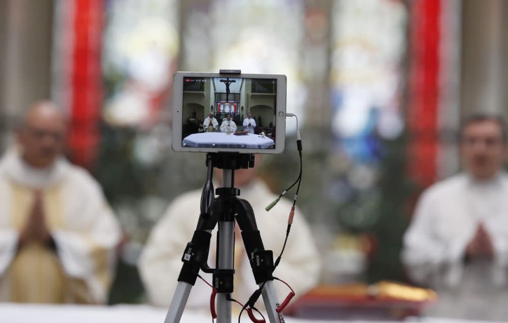 A recording device captures the delivery of Easter Mass in Queen of Peace Catholic Church in Aurora, Colo. (AP Photo/David Zalubowski)