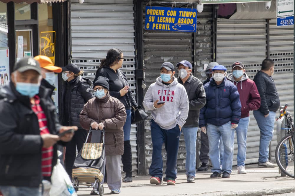 People wear face masks to protect against the coronavirus as they stand on line to grocery shop, Tuesday, April 14, 2020, in Corona neighborhood of the Queens borough of New York. (Mary Altaffer/AP)