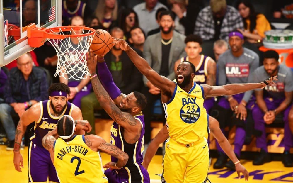 LeBron James of the Los Angeles Lakers (C) goes to the hoop under pressure from Draymond Green (R) of the Golden State Warriors during their the regular season game at the Staples Center in Los Angeles on November 13, 2019. (FREDERIC J. BROWN/AFP via Getty Images)