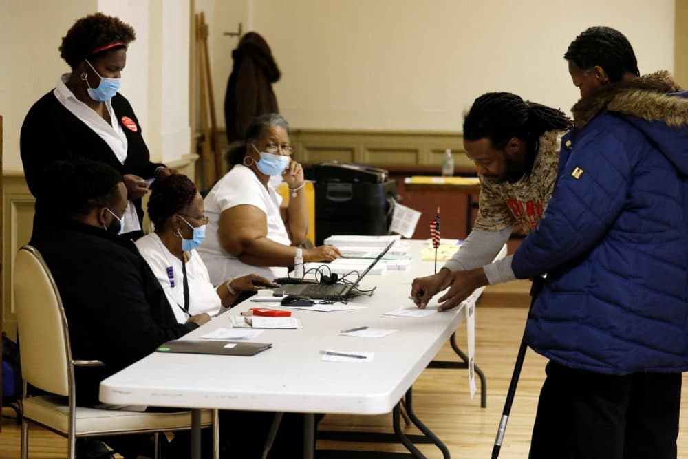 Election workers wear protective face masks as they check voters to get their to vote in the Michigan primary election at Central United Methodist Church in Detroit, Michigan, on March 10, 2020. (JEFF KOWALSKY/AFP via Getty Images)