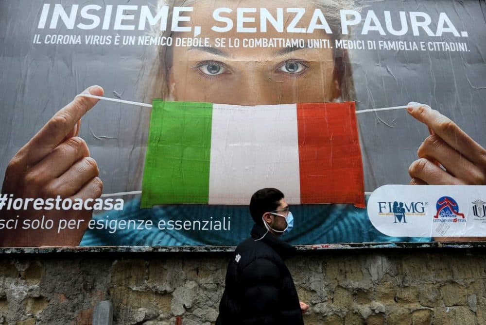 A man walks past a billboard raising awareness to the measures taken by the Italian government to fight against the spread of the COVID-19. (Carlo Hermann/AFP/Getty Images)