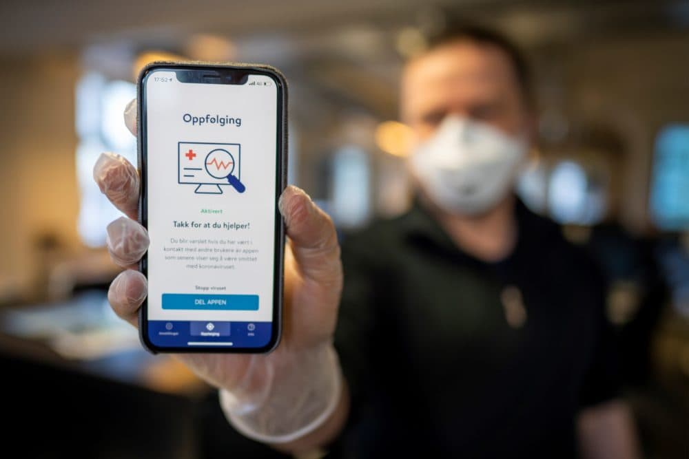A man holds a smartphone showing a tracking and tracing app launched by the National Institute of Public Health to try to halt a return of the new coronavirus, on April 17, 2020 in Oslo. (Heiko Junge /NTB Scanpix/AFP via Getty Images)