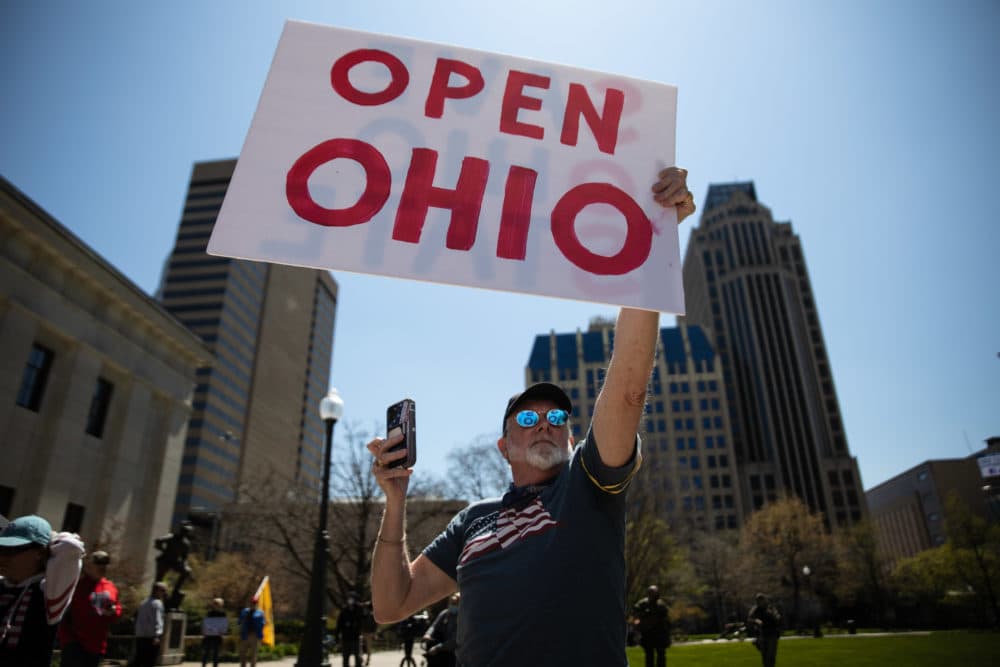 A protester is seen with an Open Ohio sign at a rally to protest the stay-at-home order amid the Coronavirus pandemic in Columbus, Ohio on April 20, 2020. (MEGAN JELINGER/AFP via Getty Images)