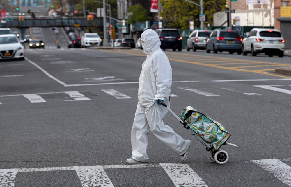 A woman wearing a hazmat suit and goggles pulls her grocery cart in the streets in Queens, a borough of New York City, amid the coronavirus pandemic on April 20, 2020 in New York City.(Johannes Eisele/AFP via Getty Images)